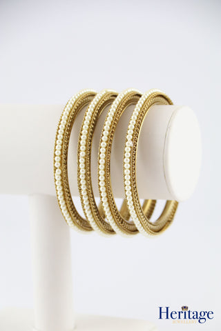 Intricately designed antique gold bangles adorned with crystals