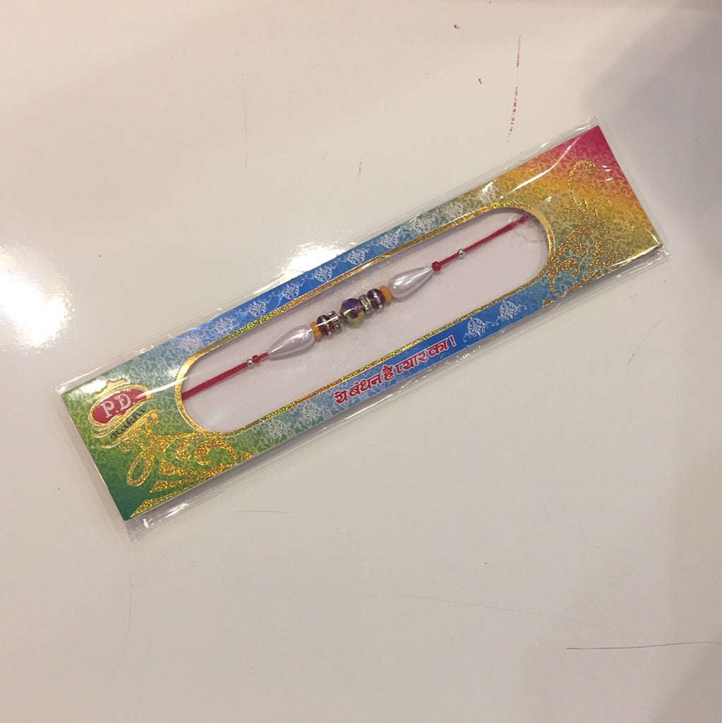 Single Rakhi With A Multicolour Bead Centre And Red Gems And White Gems And White Pearls On a Red Thread - R136