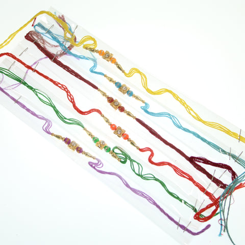 Dozen Rakhis With Orange And Gold beads on a Multicolour Thread - R130