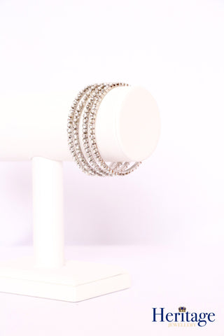 Silver bangles adorned with silver crystals.