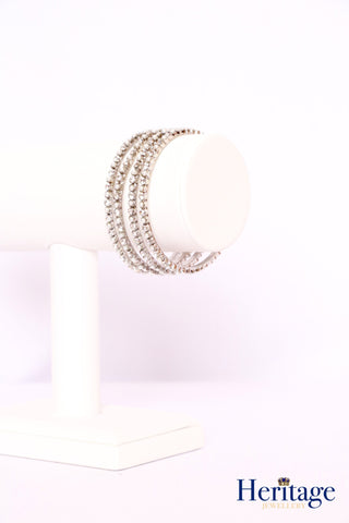 Rose gold bangles adorned with silver crystals and pearls.