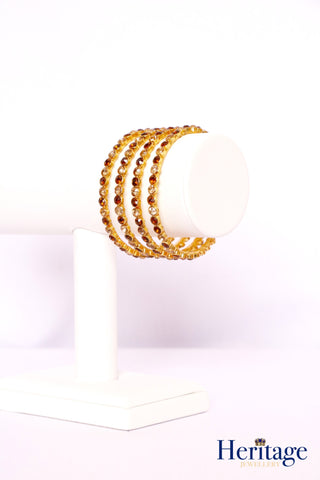 Intricately designed antique gold bangles adorned with crystals