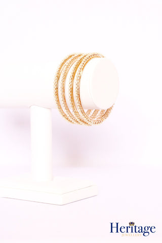 Intricately designed antique gold bangles adorned with crystals