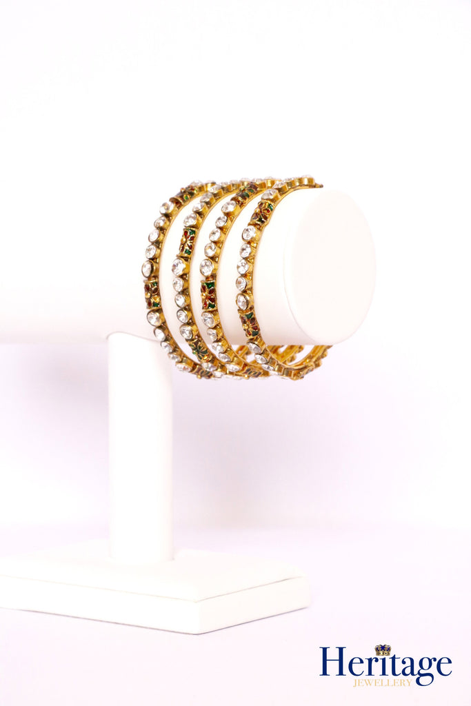 Antique gold kundan style bangles adorned with silver crystals.