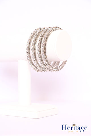 Antique gold bangles adorned with silver crystals.