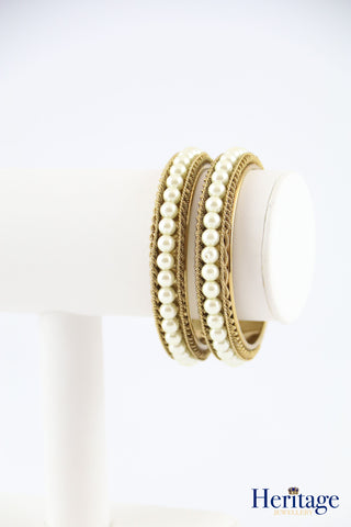 Antique gold kundan style bangles adorned with silver crystals.