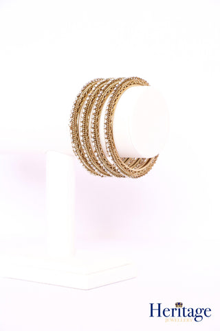 Rose gold bangles adorned with silver crystals and pearls.